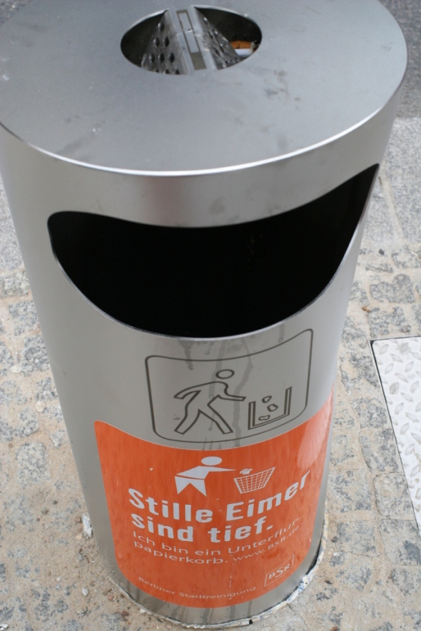The German notice says "fixed bins are deep. I am an underfloor paper bin." (sorry for the dodgy translation)